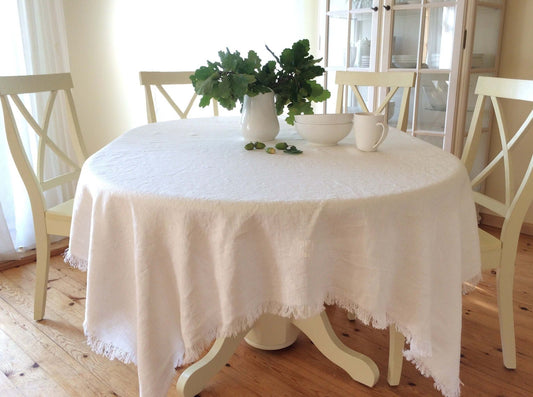 Elegant milky white linen tablecloth on dining table